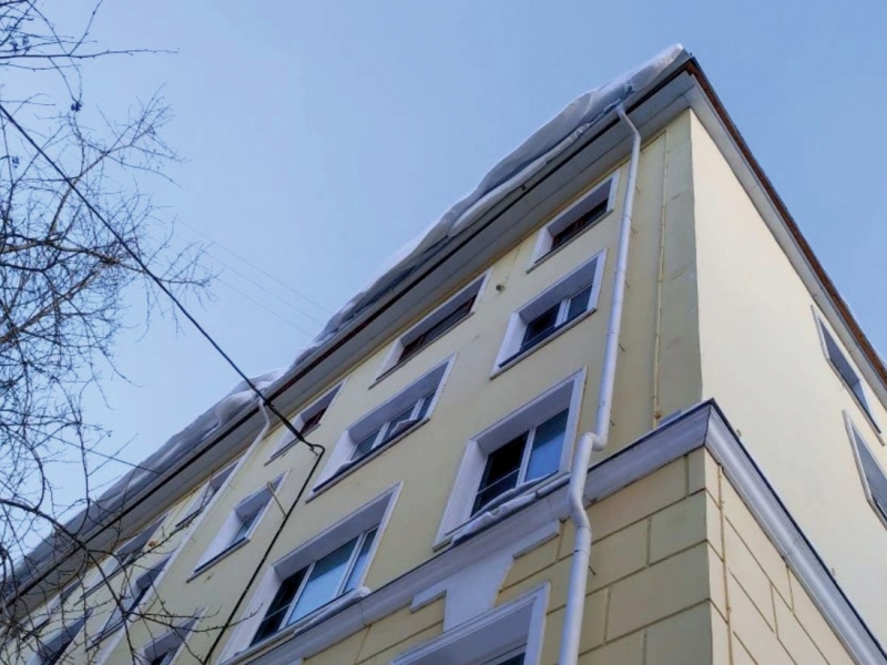Снег на крыше дома в Мурманске угрожает прохожим Снег
